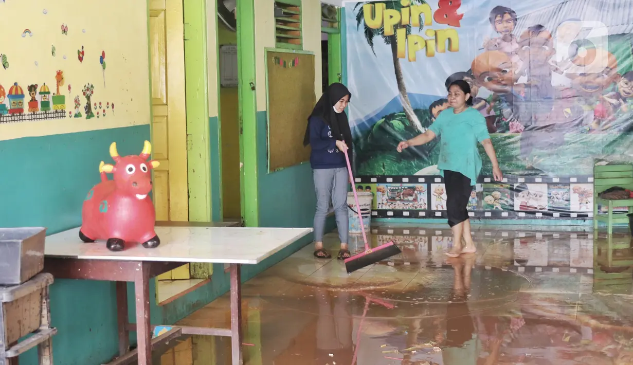 Warga membersihkan lumpur sisa pascabanjir di perumahan Ciledug Indah, Tangerang Senin (21/2/2021). Banjir yang menggenangi perumahan tersebut membuat warga mengalami kerugian cukup besar karena barang-barang berharga mereka rusak parah. (Liputan6.com/Angga Yuniar)