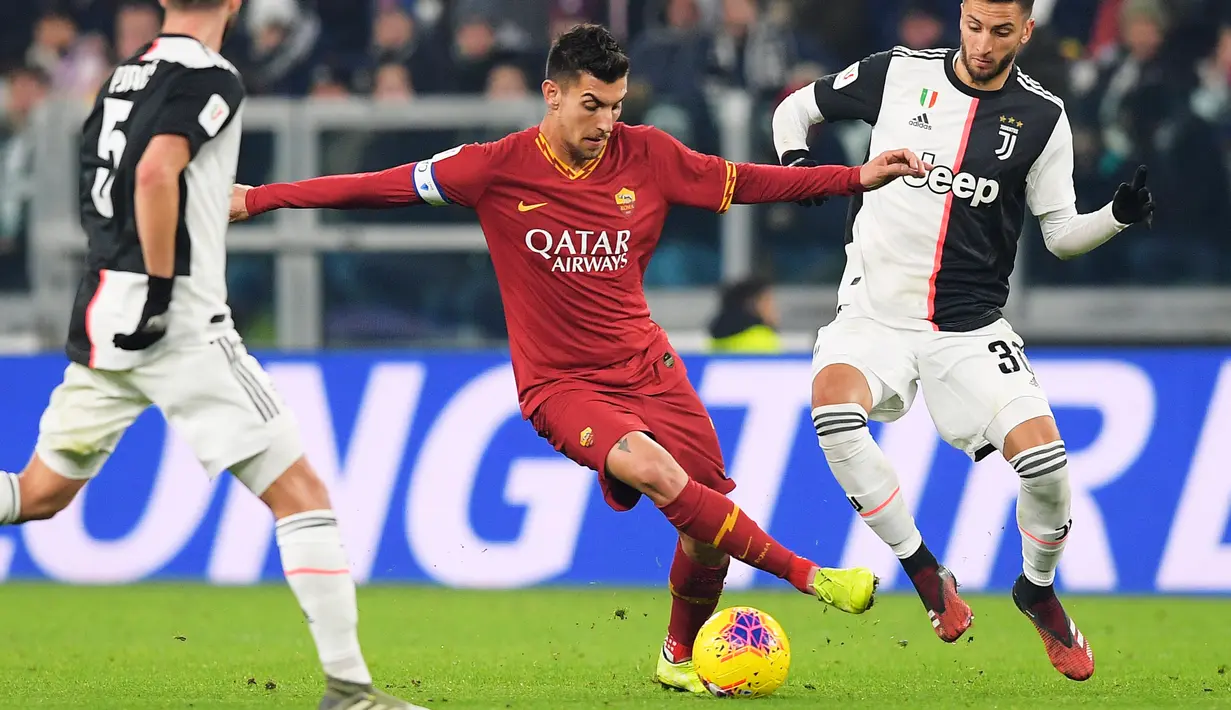 Pemain AS Roma Lorenzo Pellegrini (tengah) berusaha melewati pemain Juventus Rodrigo Bentancur (kanan) pada pertandingan Coppa Italia di Turin, Italia, Rabu (22/1/2020). Juventus menggilas AS Roma 3-1 dan berhasil lolos ke semifinal. (Luciano Rossi/LaPresse via AP)