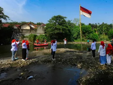 Warga RW 07 melakukan pengibaran bendera Merah Putih pada aliran Sungai Ciliwung yang mengering akibat kemarau panjang di Kedung Halang, Kota Bogor, Jawa Barat, Kamis (17/8/2023). (merdeka.com/Arie Basuki)
