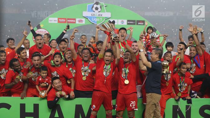 Kapten tim Persija, Ismed Sofyan dan Bambang Pamungkas mengangkat piala Liga 1 Indonesia usai menumbangkan Mitra Kukar di Stadion GBK, Jakarta, Minggu (9/12). Persija meraih juara Liga 1 Indonesia 2018 dengan 62 poin. (Liputan6.com/Helmi Fithriansyah)