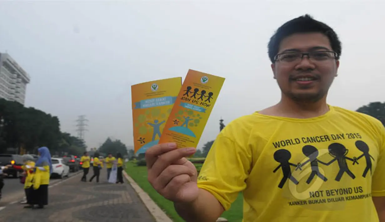 Seorang aktivis menunjukkan brosur mengenai kanker dalam aksi damai di Jalan Bundaran Tugu Tani, Jakarta, Rabu (4/2/2015). (Liputan6.com/Herman Zakharia) 