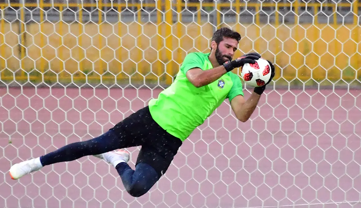 Kiper Brasil, Alisson menangkap bola saat berlatih dengan rekan setimnya jelang menghadapi Belgia dalam perempat final Piala Dunia 2018 di Stadion Tsentralny, Kazan, Rusia, Kamis (5/7). (Luis Acosta/AFP)