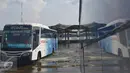 Bus melintasi banjir akibat air laut pasang atau rob yang menggenangi Terminal Terboyo di Semarang, Minggu (15/5/2016). Banjir rob tersebut mengakibatkan penumpang memilih turun di luar terminal, sehingga aktivitas di dalam terminal lumpuh. (Foto: Gholib)