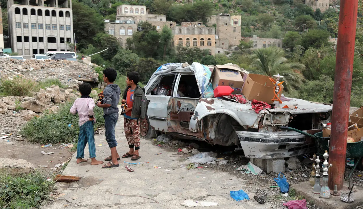 Anak-anak membeli permen di sebuah toko darurat di kawasan Jabal Sabr, Yaman pada 28 September 2019. Majd al-Din al-Shamiri (16) mengubah mobil keluarganya yang rusak parah, akibat perang yang melanda, menjadi toko darurat untuk mencari nafkah di tengah keadaan sulit. (Ahmad AL-BASHA/AFP)
