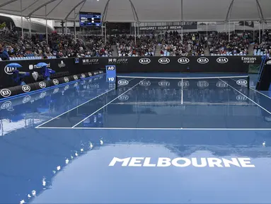 Kondisi lapangan tenis tempat berlangsungnya turnamen Australia Terbuka di Melbourne, Australia, Senin (20/1/2020). Pertandingan Roger Federer melawan Steve Johnson sempat terhenti akibat hujan deras yang mengguyur Rod Laver Arena. (AP Photo/Andy Brownbill)