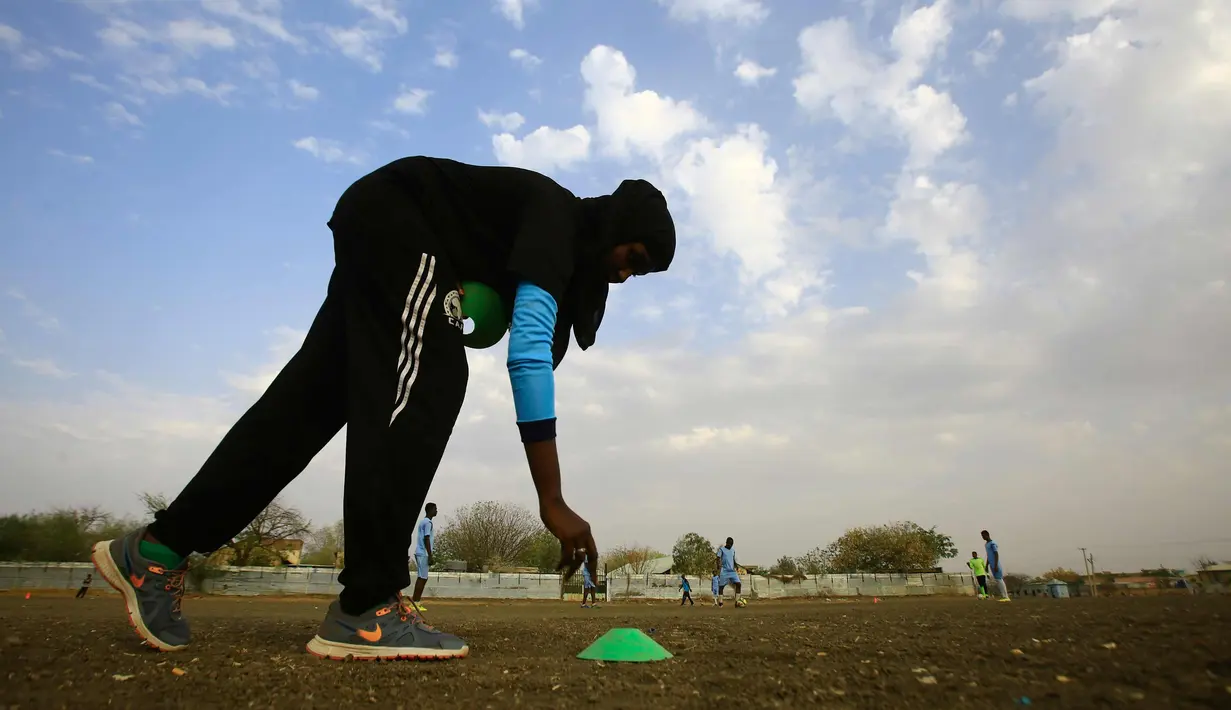 Salma al-Majidi saat melatih klub Al-Ahly Al-Gadaref setelah melatih sesi latihan di kota Gedaref, timur Khartoum (17/2). Salma tahu cara untuk mengambil bagian dalam olahraga yang dicintainya adalah melatih tim sepak bola pria. (AFP Photo/Ashraf Shazly)