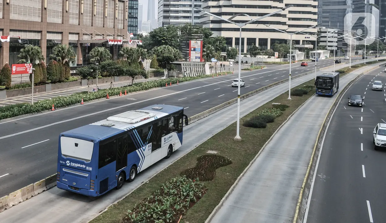 Bus Transjakarta saat melintas di Jalan Sudirman, Jakarta, Minggu (2/8/2020). PT Transjakarta akan menambah armada sebanyak 155 mengantisipasi lonjakan pelanggan saat diberlakukan kebijakan ganjil genap di sejumlah ruas jalan utama Jakarta pada Senin, 3 Agustus 2020. (merdeka.com/Iqbal Nugroho)