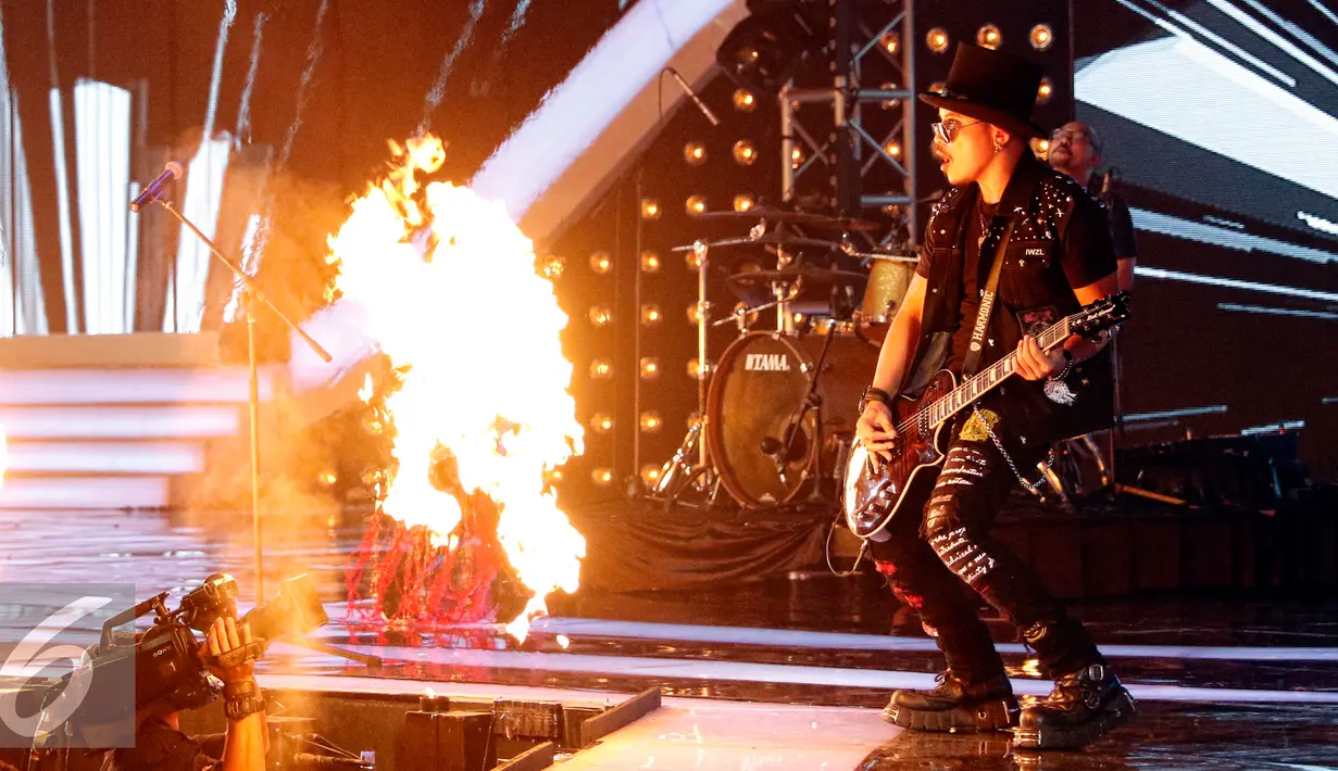Aksi gitaris band Kotak saat ikut memeriahkan panggung HUT SCTV ke-25, Jakarta, Senin (24/8/2015). Merayakan hari jadinya yang ke-25, SCTV menampilkan hiburan selama 25 jam nonstop. (Liputan6.com/Yoppy Renato)