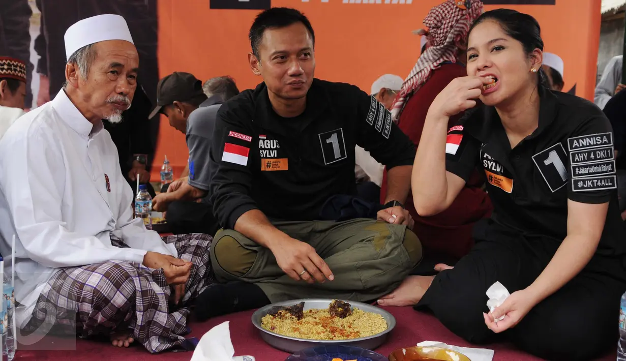 Annisa Pohan mendampingi suaminya, Calon Gubernur DKI Jakarta Agus Harimurti Yudhoyono menikmati nasi kebuli di Kampung Bidaracina, Jakarta, Rabu (30/1). Agus menggelar kampanye tatap muka dengan para warga di wilayah itu. (Liputan6.com/Gempur M Surya)