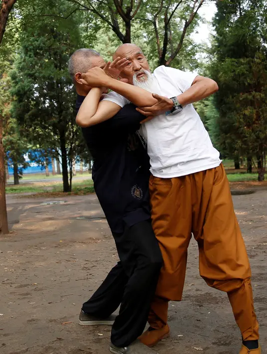 Master kungfu Li Liangui mempraktekan jurus kungfunya saat berlatih bersama rekannya di sebuah taman di Beijing, China, pada 30 Juni 2016. Selama 50 tahun, Li Liangui telah mendalami ilmu seni bela ini. (REUTERS/Kim Kyung-Hoon)