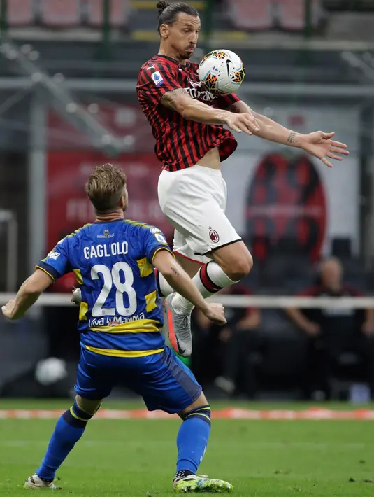 Penyerang AC Milan, Zlatan Ibrahimovic mengontrol bola dari kawalan pemain Parma, Riccardo Gagliolo pada pertandingan lanjutan Liga Serie A Italia di Stadion San Siro di Milan, Italia (15/7/2020). AC Milan menang telak 3-1 atas Parma. (AP Photo/Luca Bruno)