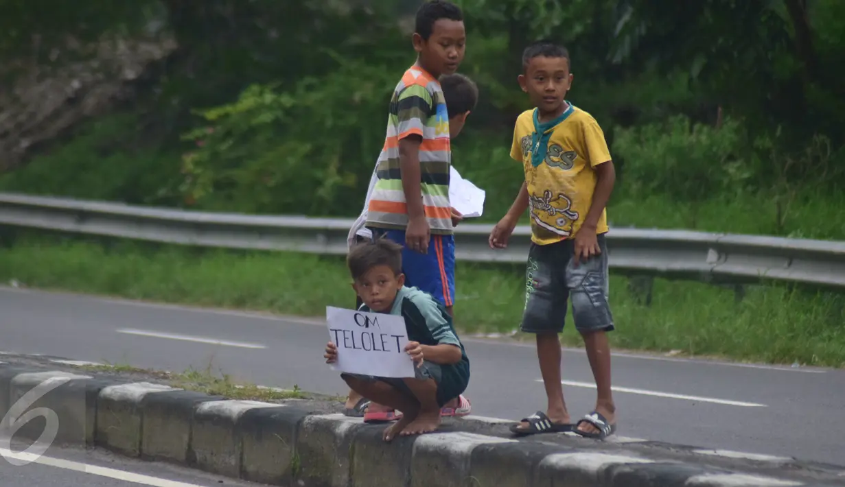 Anak-anak menunggu bus untuk meminta bunyi klakson telolet dari bus yang lewat di jalan raya A Yani Surakarta, Solo, Kamis (22/12). Fenomena ini mendunia setelah beberapa artis dan tokoh terkenal dunia berkomentar di media sosial. (Liputan6.com/Gholib)