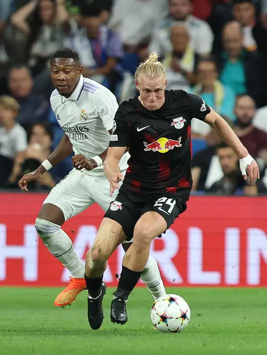Bek Real Madrid David Alaba (kiri) berebut bola dengan pemain tengah Red Bull Leipzig Xaver Schlager pada matchday 2 Liga Champions berlangsung di Santiago Bernabeu, Kamis (15/9/2022) dini hari WIB. Real Madrid menang susah payah 2-0 kala menjamu RB Leipzig. (Photo by Thomas COEX / AFP)