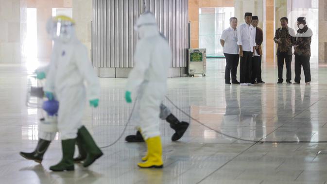 Presiden Joko Widodo atau Jokowi menyaksikan petugas menyemprotkan cairan disinfektan di Masjid Istiqlal, Jakarta, Jumat (13/3/2020). Proses sterilisasi ini dilakukan dalam rangka mencegah penularan virus corona Covid-19. (Liputan6.com/Faizal Fanani)