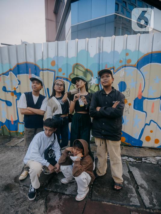 Para remaja dari berbagai daerah di pinggiran Jakarta berpose di Taman Sudirman, Jakarta, Rabu (6/7/2022). Tempat ini viral karena jadi ajang adu fashion anak Citayam, Bekasi hingga Bojong Gede. Mereka mengenakan kemeja flanel oversize, celana model 90-an seperti boot cut
atau cutbray, sneakers klasik, dan topi. (Liputan6.com/Faizal Fanani)