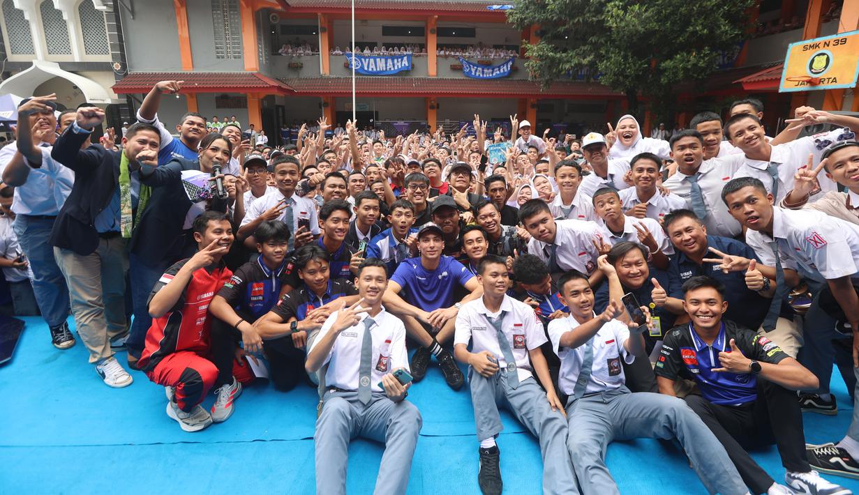 Setelah shakedown test, Toprak Razgatlioglu akan melakukan uji coba resmi MotoGP pada 3-5 Februari 2026. Tampak dalam foto, pembalap rookie Prima Pramac Racing, Toprak Razgatlioglu (tengah) berfoto bersama siswa/siswi SMK Negeri 39, kawasan Cempaka Putih, Jakarta Pusat, Selasa (20/1/2026). (Bola.com/M Iqbal Ichsan)