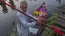 Seorang penjual bunga Kashmir menunggu pelanggan saat ia berdiri di atas perahunya di pasar sayur terapung di Danau Dal, Srinagar, Kashmir, India, Sabtu (7/8/2021). Pasar terapung ini menjadi salah satu sumber pendapatan utama penghuni Danau Dal. (AP Photo/Dar Yasin)