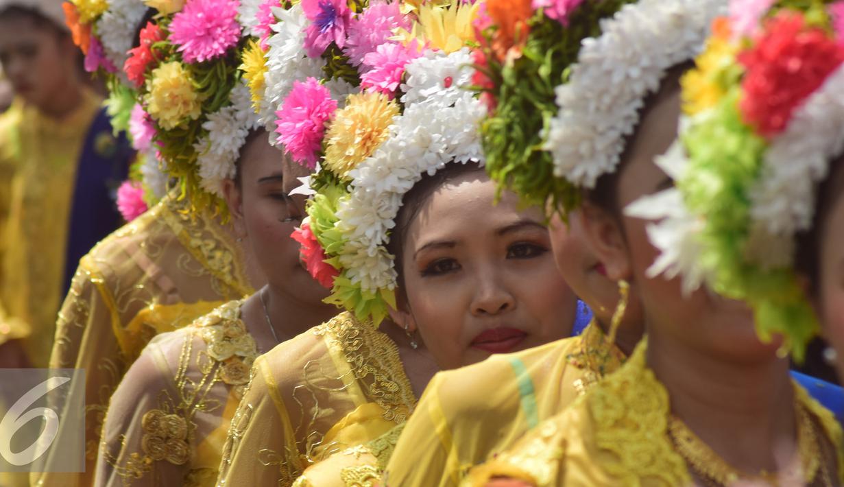 Para gadis bermahkotakan rangkaian bunga-bunga saat pawai Tradisi Ngarot di Indramayu, Minggu, (9/10). Mahkota bunga dalam Tradisi Ngarot diartikan sebagai lambang kesucian. (Liputan6.com/Gholib)
