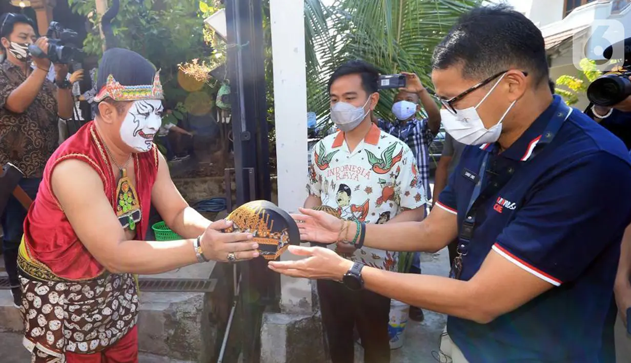 Menteri Pariwisata dan Ekonomi Kreatif Sandiaga Salahudin Uno menerima blangkon jawa pada kunjungannya di Solo, Jawa Tengah, Sabtu (09/10/2021). Sandiaga mengatakan lapangan kerja yang tercipta ternyata cukup banyak untuk pengerjaan satu set wayang. (Liputan6.com/HO/Parekraf)
