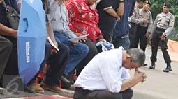 Seorang jemaat terlihat duduk di bawah saat melaksanakan ibadah di depan Istana Negara, Jakarta, Minggu (17/1/2016). Mereka kembali meminta agar pemerintah dapat memberikan solusi bagi permasalahan tempat ibadah mereka. (Liputan6.com/Immanuel Antonius)