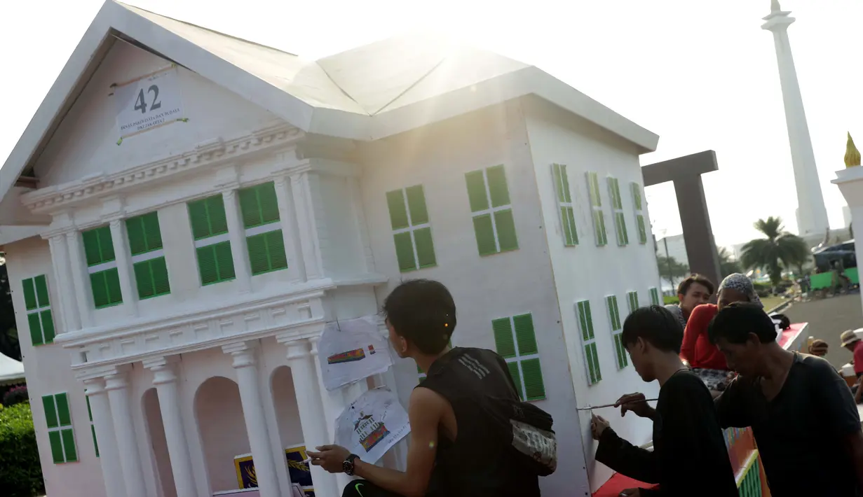 Pekerja menyelesaikan pembuatan miniatur Museum Fatahillah di atas kendaraan hias di kawasan Monas, Jakarta, Jumat (28/6/2019). Kendaraan hias tersebut dipersiapkan untuk mengikuti Jakarnaval 2019 yang merupakan puncak perayaan HUT ke-492 DKI Jakarta, Minggu (30/6). (Liputan6.com/Helmi Fithriansyah)