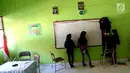 Sejumlah siswi memasang papan tulis yang jatuh akibat gempa di dalam kelas SMP Negeri 6 Palu, Sulawesi Tengah, Senin (8/10). Pascagempa dan tsunami Palu, pihak sekolah melakukan pendataan untuk mengetahui jumlah siswa sekolah. (Liputan6.com/Fery Pradolo)