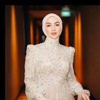 Tampil anggun dalam balutan dress brokat berwarna beige, Citra memadukannya dengan hijab segi empat yang dililit rapi ke belakang. Siluet clean dan warna lembut menciptakan kesan feminin sekaligus classy. [@ciraciki].