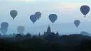 Sejumlah balon udara terbang di atas kuil tua selama matahari terbit di Bagan, distrik Nyaung U, Myanmar tengah (16/12). Selain balon udara, banyak wisatawan datang ke Bagan karena ingin melihat pagoda, stupa, dan warisan kuno. (AP Photo/Aung Shine Oo)