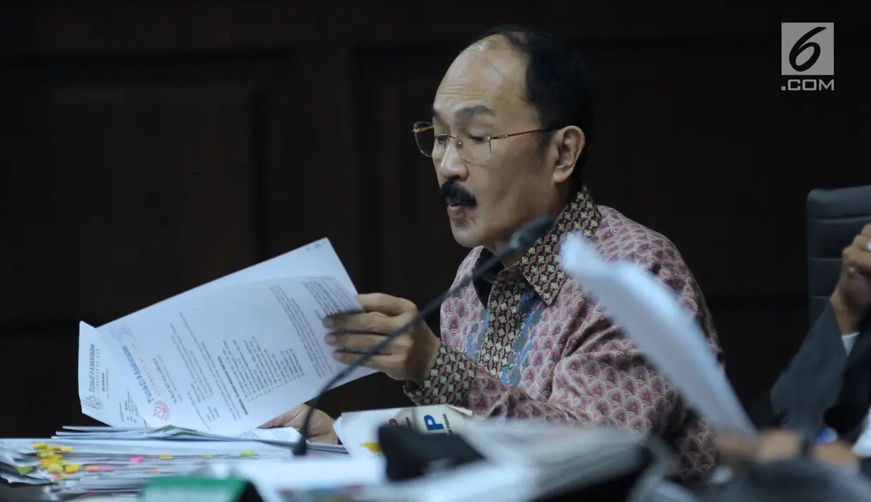 Terdakwa kasus merintangi penyidikan dugaan korupsi e-KTP, Fredrich Yunadi melihat-lihat berkas pada sidang lanjutan di Pengadilan Tipikor, Jakarta, Kamis (12/4). Sidang mendengar keterangan saksi. (Liputan6.com/Helmi Fithriansyah)