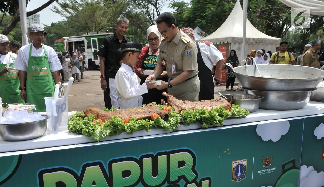 Gubernur DKI Jakarta Anies Baswedan memberikan makanan daging kurban olahan chef hotel bintang 5 kepada anak yatim di Monas, Jakarta, Senin (12/8/2019).  Sebanyak 5.000 boks makanan dari daging kurban dibagikan Pemprov DKI kepada warga Jakarta menengah ke bawah. (merdeka.com/Iqbal S. Nugroho)