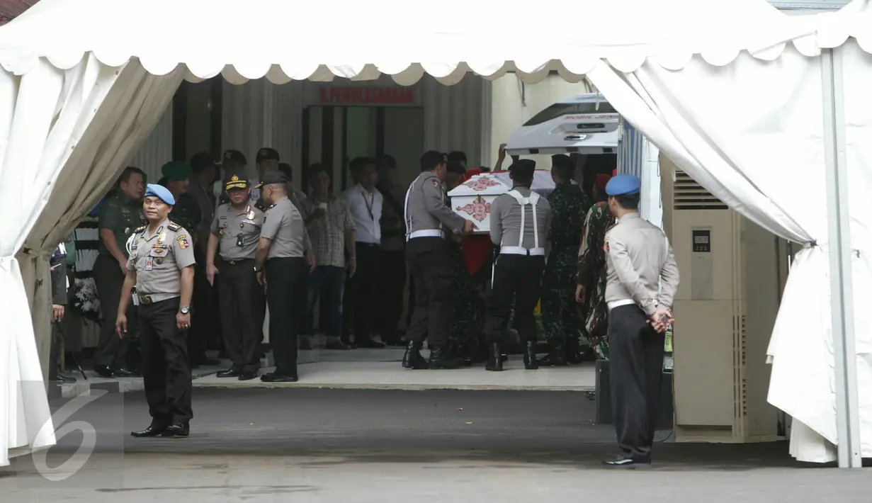 Petugas TNI dan Polisi mengeluarkan peti jenazah yang diselimuti bendera merah putih untuk dibawa masuk ke dalam ruangan RS Polri guna menjalani proses identifikasi, Jakarta, Senin (21/3/2016). (Liputan6.com/Yoppy Renato)