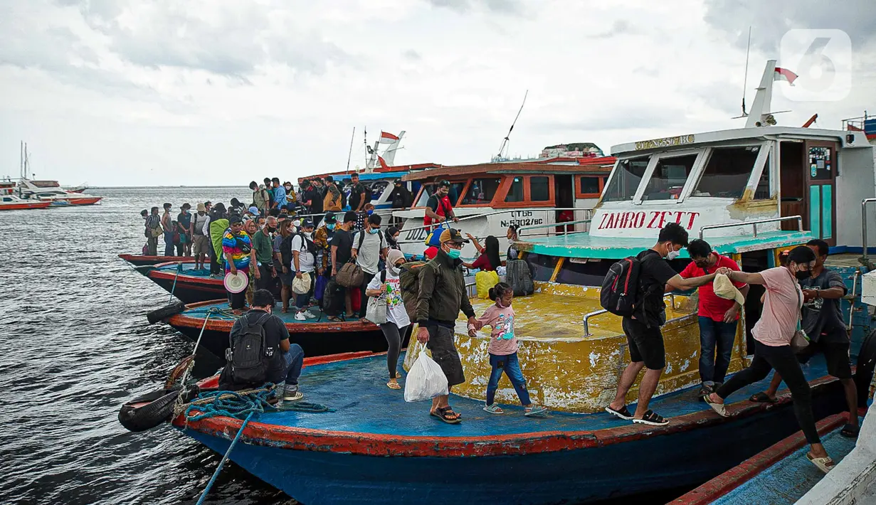 Wisatawan turun dari kapal usai liburan Tahun Baru di Pelabuhan Kali Adem, Jakarta, Minggu (2/1/2022). Wisatawan memadati Pelabuhan Kali Adem usai berlibur ke pulau-pulau kecil di utara Jakarta untuk merayakan Tahun Baru. (Liputan6.com/Faizal Fanani)