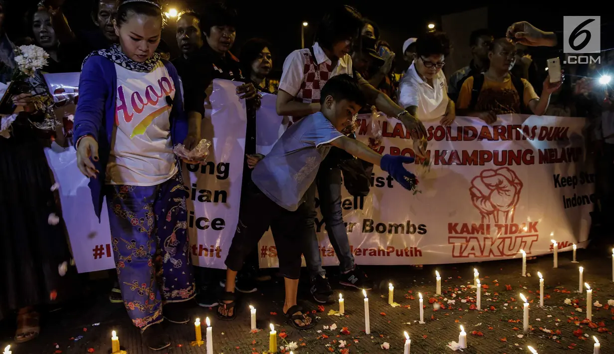 assa dari Solidaritas Merah Putih menggelar aksi lilin dan tabur bunga di lokasi bom Terminal Kampung Melayu, Jakarta, Kamis (25/5). Aksi tersebut sebagai bentuk malam solidaritas duka untuk bom Kampung Melayu.(Liputan6.com/Faizal Fanani)