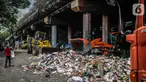 Petugas PPSU menggunakan kendaraan alat berat untuk mengangkut tumpukan sampah di kolong tol Wiyoto Wiyono, Tanjung Priok, Jakarta, Selasa (5/11/2019). Kolong Tol Tol Wiyoto-Wiyono berubah menjadi tempat penampungan sampah rumah tangga dari tiga kelurahan di kawasan itu. (Liputan6.com/Faizal Fanani)
