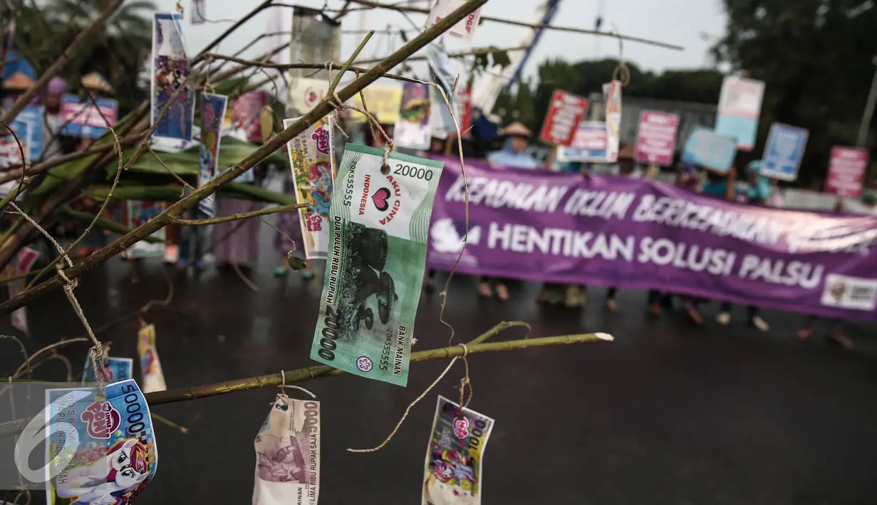 Tangkai pohon kering dihiasi uang mainan dibawa saat aksi wanita menuntut keadilan iklim di depan Istana Negara, Jakarta, Selasa (17/5). Mereka meminta pemerintah tegas dan konsisten dalam langkah mengatasi perubahan iklim. (Liputan6.com/Faizal Fanani)