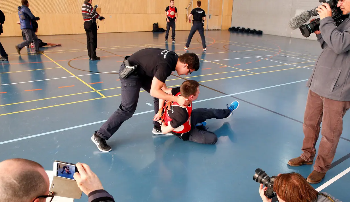 Sejumlah awak media mengbamil gambar Anggota Pontifical Swiss Guard saat anggota penjaga Kepausan Swiss Vatikan melumpuhkan musuh saat latihan di pangkalan militer Swiss di isone, Swiss, (15/11). (REUTERS/Arnd Wiegmann)