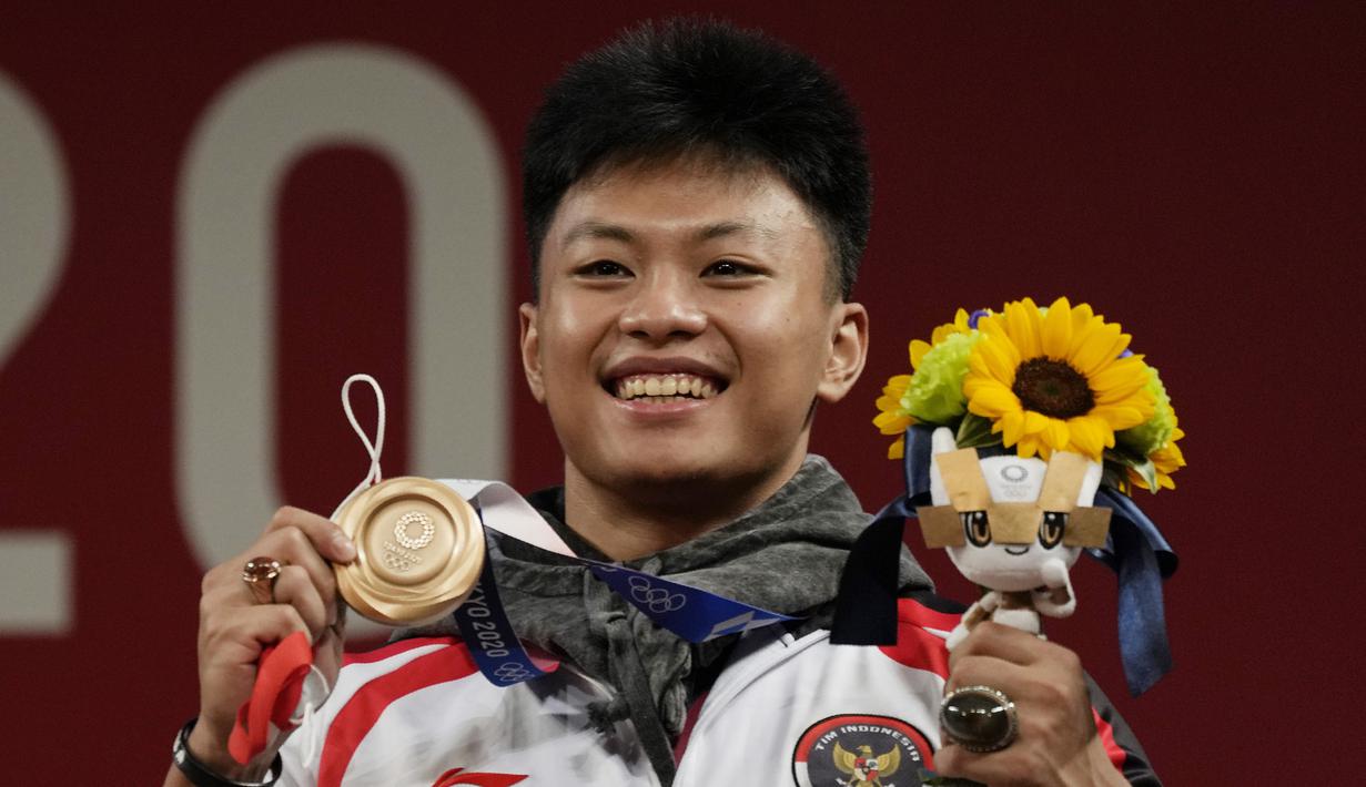 Lifter Indonesia, Rahmat Erwin Abdullah menyumbang medali ketiga bagi Indonesia dari cabang angkat Besi kelas 73 kg putra di Olimpiade Tokyo 2020, Rabu (28/7/2021). Ia meraih medali perunggu usai menempati posisi teratas di Grup B, dan ketiga secara keseluruhan. (Foto: AP/Luca Bruno)