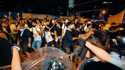 Polisi terlibat bentrok dengan pengunjuk rasa yang menolak RUU Ekstradisi di luar gedung parlemen, Hong Kong, Senin (10/6/2019). Pihak berwenang menyatakan massa aksi mencapai 240.000 orang. (AP Photo/Kin Cheung)