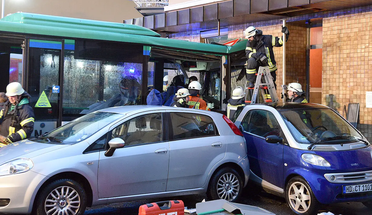 Petugas mengevakuasi bus sekolah yang menabrak tembok sebuah toko di Eberbach dekat Mannheim, Jerman, Selasa (16/1). Bus ini melaju dengan kecepatan cukup tinggi menabrak beberapa kendaraan sebelum kemudian menabrak dinding toko. (Rene Priebe/dpa via AP)