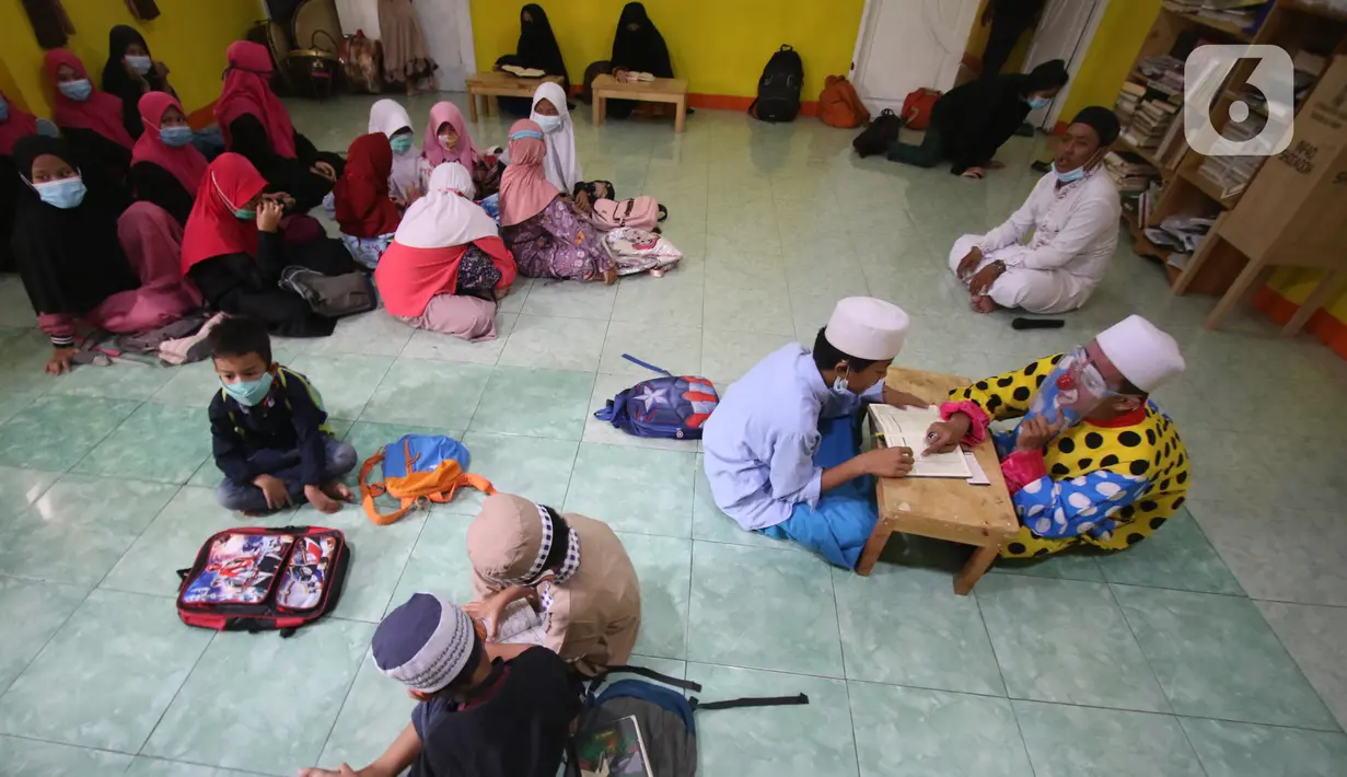 Anak-anak belajar mengaji dengan Yahya Edward yang menggunakan kostum badut di Tangerang, Banten, Kamis (29/4/2021). Mengajar ngaji menggunakan kostum badut tersebut untuk memotivasi anak-anak agar tetap semangat belajar sekaligus untuk menghibur anak didiknya. (Liputan6.com/Angga Yuniar)