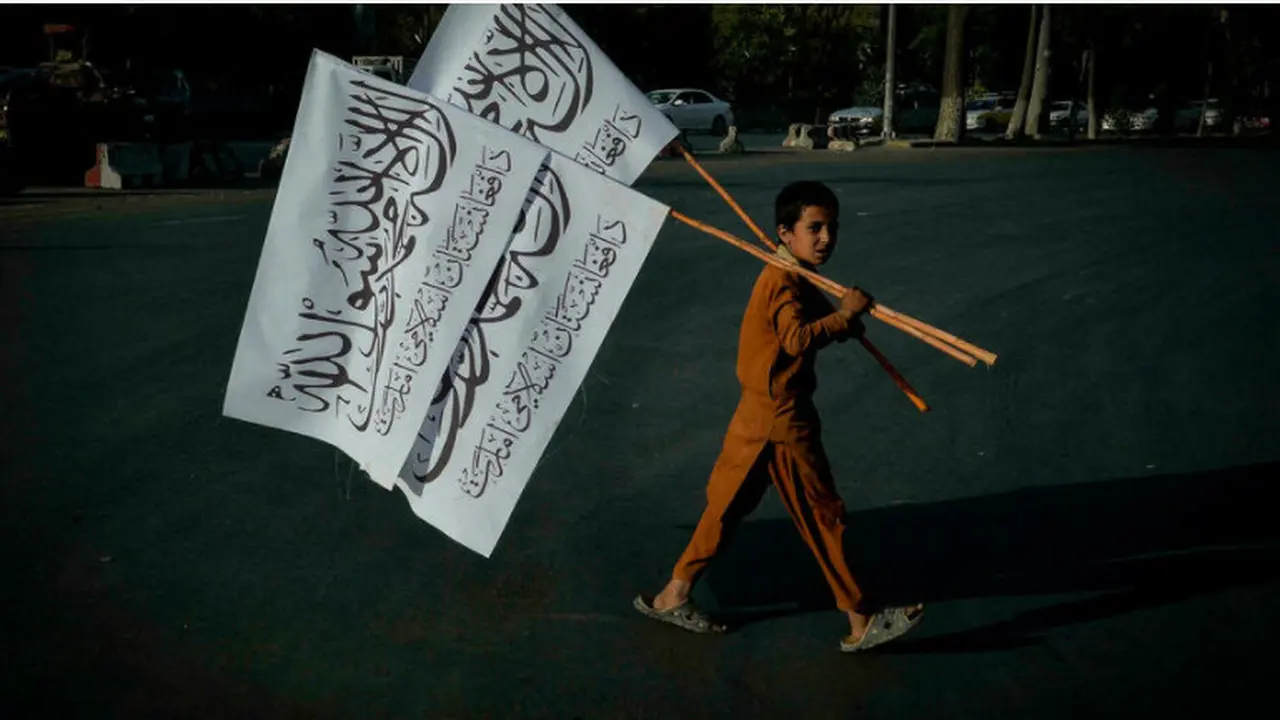 Seorang anak laki-laki membawa bendera Taliban untuk dijual di ibu kota Afghanistan Kabul Hoshang Hashimi. (AFP)