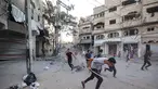 Orang-orang berlari mencari perlindungan setelah serangan Israel yang menargetkan sebuah bangunan di kamp pengungsi Palestina Bureij di Jalur Gaza tengah pada 19 Oktober 2025. (Eyad BABA/AFP)