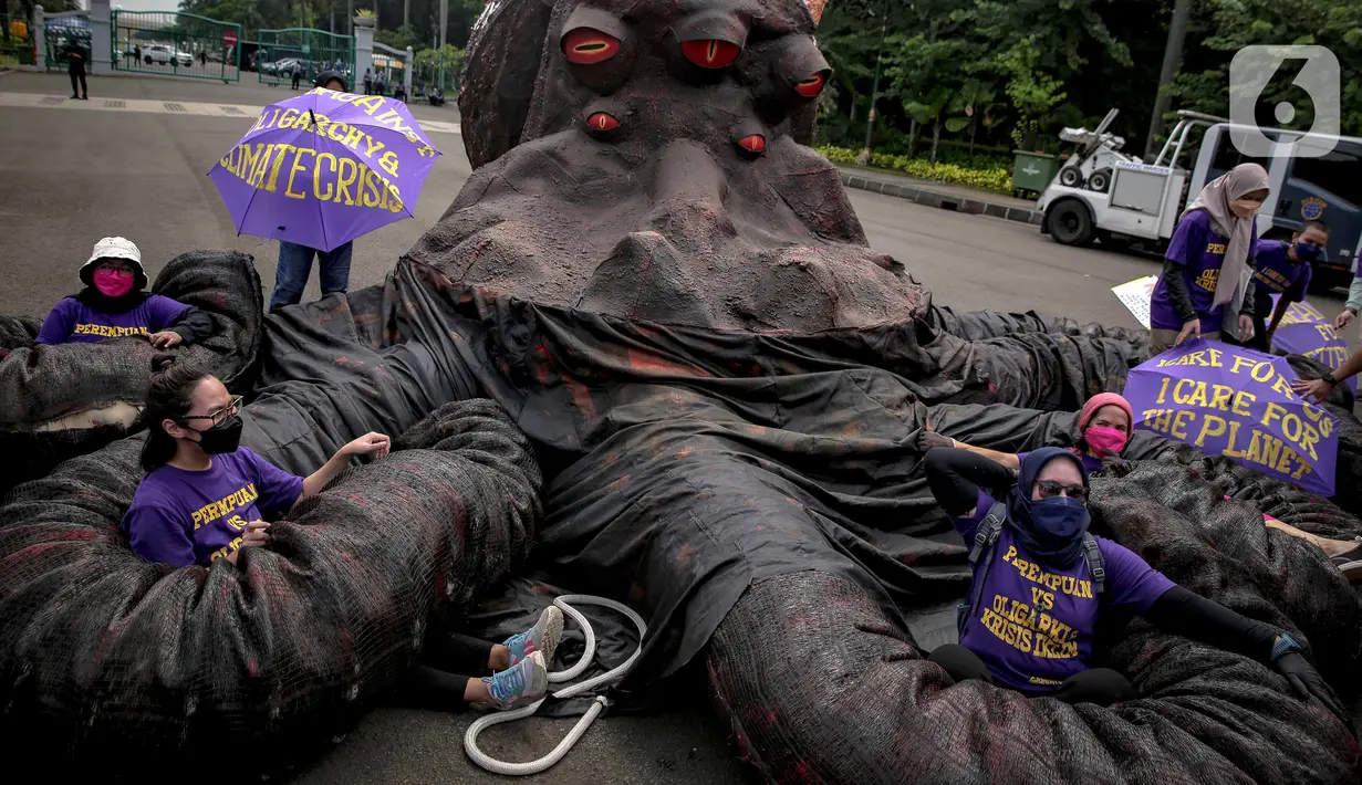 Sejumlah massa aksi berada di antara replika gurita raksasa oligarki saat aksi di Patung Kuda, Jakarta, Selasa (8/3/2022). Aksi tersebut untuk memperingati Hari Perempuan Internasional serta menuntut pengesahan RUU TPKS yang partisipatif dalam pembahasan dan pro korban. (Liputan6.com/Faizal Fanani)