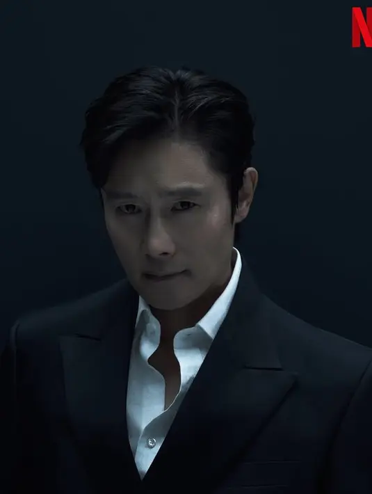 Begitupula Lee Byung-hun kembali berperan sebagai The Frontman. Ia mengenakan jas hitam dipadukan inner kemeja putih dengan kancing atas dibuka. [@netflixkr]