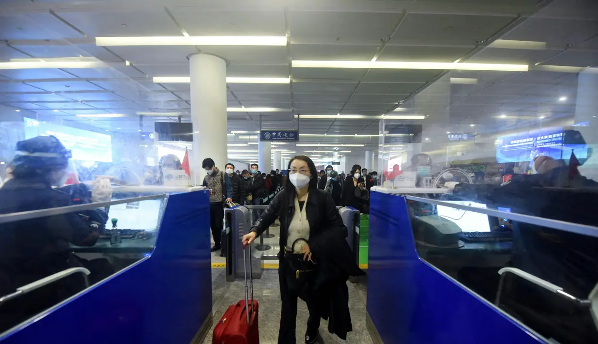 Penumpang mengantre untuk melewati bea cukai setelah tiba di Bandara Internasional Hangzhou Xiaoshan di provinsi Zhejiang timur China (8/1/2023). China mencabut persyaratan karantina untuk pelancong yang datang pada (8/1), mengakhiri isolasi yang diberlakukan sendiri selama hampir tiga tahun bahkan saat negara tersebut berjuang melawan wabah lonjakan kasus Covid-19. (AFP/STR)