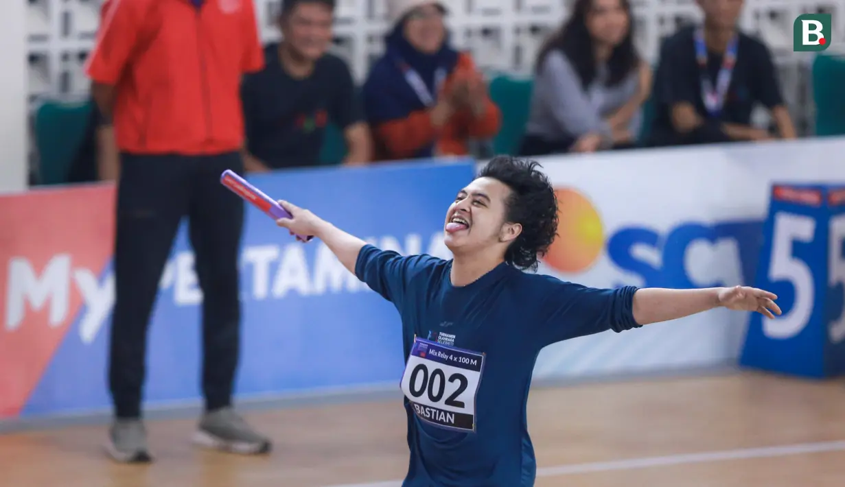 Selebritas Indonesia, Bastian Steel melakukan selebrasi menjelang garis finis saat berlomba pada cabang olahraga lari estafet 400 meter nomor campuran Turnamen Olahraga Selebriti Indonesia (TOSI) di GOR UNJ, Rawamangun, Jakarta, Minggu (30/07/2023). Timnya berhasil finis dengan catatan waktu 1 menit 0,59 detik. (Bola.com/Bagaskara Lazuardi)