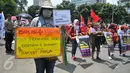 Seorang massa membawa poster saat aksi long march menuju Istana Presiden, Jakarta, Selasa (8/3). Aksi memperingati Hari Perempuan Internasional ini menuntut pemerintah memberikan perlindungan terhadap perempuan Indonesia. (Liputan6.com/Gempur M Surya)