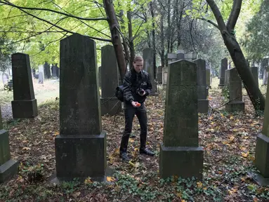 Dominik Creazzi, pemburu hantu dari "Paranormal Investigator" mencari aktivitas gaib di pusat pemakaman tua di Wina, Austria, 20 Oktober 2016. Pemakaman ini disinyalir memiliki aura mistis yang kental dengan aktivitas makhluk halus. (JOE KLAMAR/AFP)