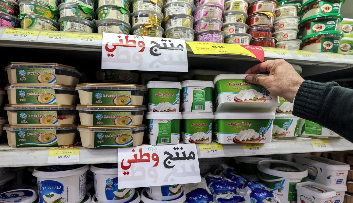 Slogan tersebut ada di mana-mana di salah satu jaringan supermarket terkenal di Tepi Barat, di mana produk-produk "Made in Palestine" seperti air, susu, dan tisu toilet menjadi kebanggaan mereka. (Jaafar ASHTIYEH / AFP)