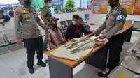 Kapolsek Semayang, AKP Abu Sangit bersama anggotanya menunjukan barang bukti Sajam jenis parang yang disitas dari penumpang kapal. (Liputan6.com/Apriyanto)